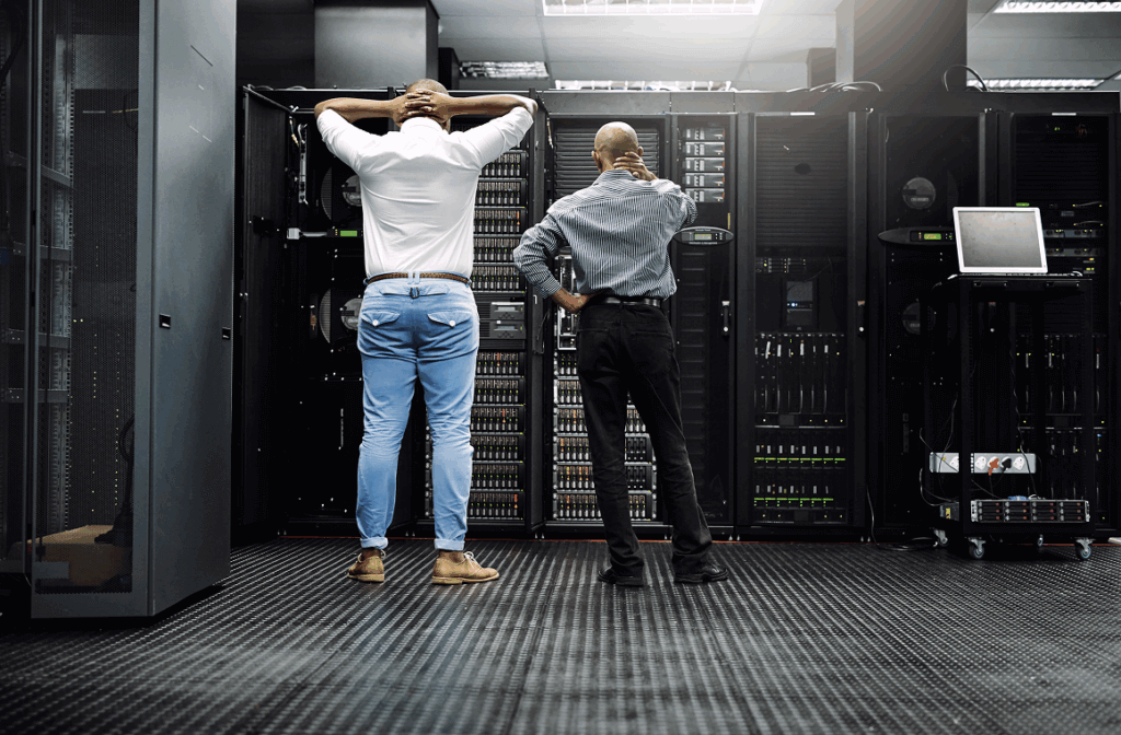 RPO vs. RTO uitgelegd: twee IT-specialisten analyseren servers in een datacenter om hersteldoelen en dataverlies te beperken binnen een Business Continuity Plan